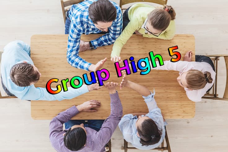 Group sitting around a table and giving a high five