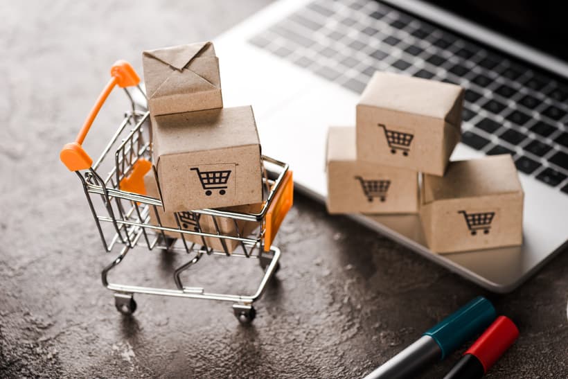 How to Create Shoppable Videos for eCommerce - toy shopping cart with small carton boxes near laptop, e-commerce concept