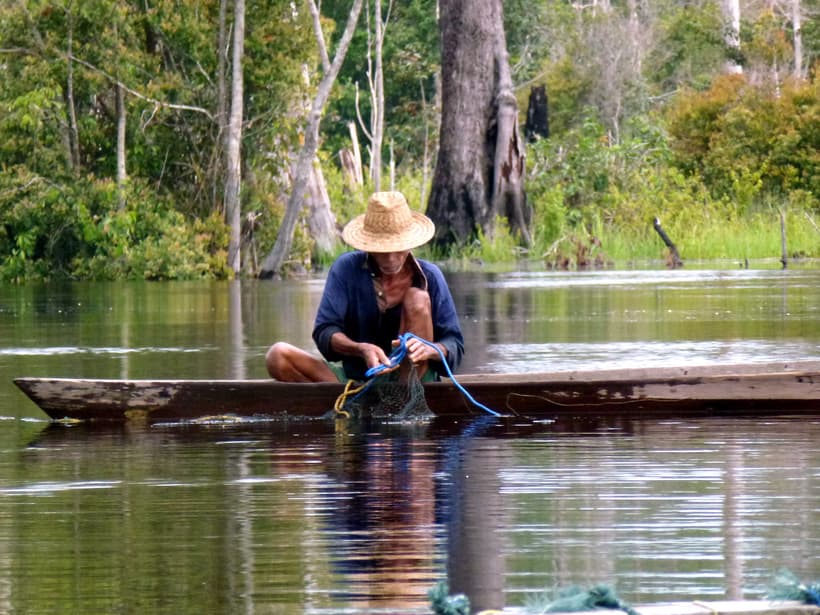 Katingan Peatlands Conservation, Indonesia, man fishing on canoe